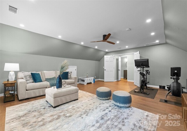 living area with light wood-type flooring, lofted ceiling, a ceiling fan, baseboards, and recessed lighting