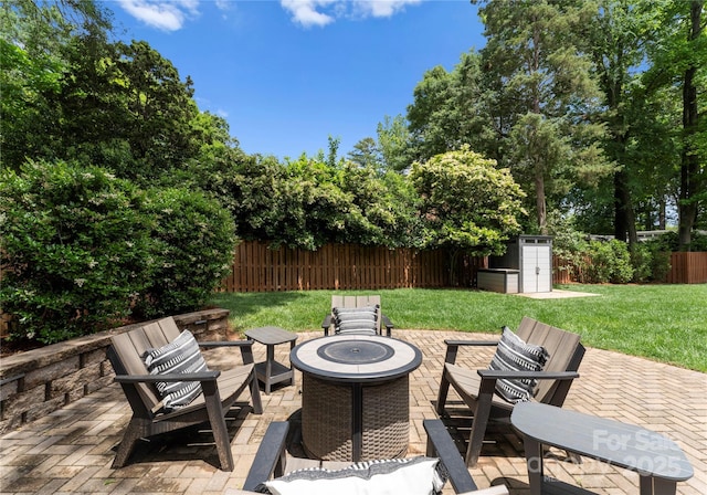 view of patio featuring a fire pit, a storage unit, and an outdoor structure