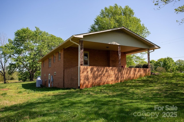 view of property exterior featuring a lawn, brick siding, and central air condition unit