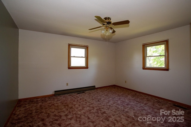 carpeted empty room featuring a baseboard heating unit, a ceiling fan, and baseboards