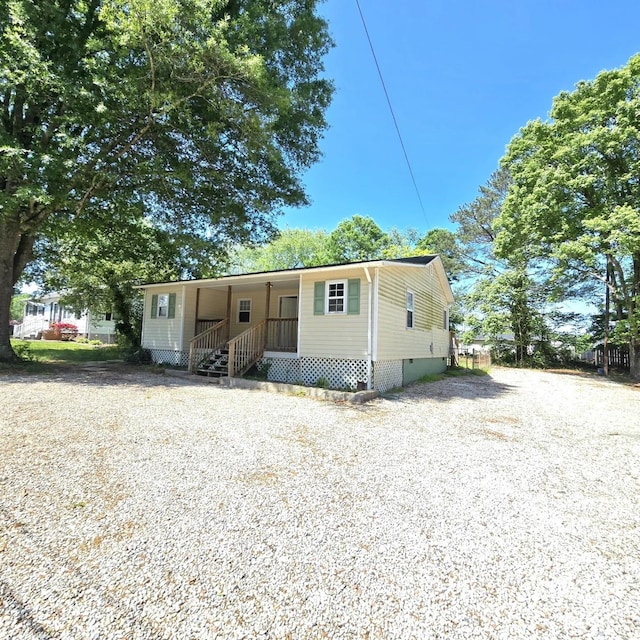 manufactured / mobile home featuring a porch, driveway, and crawl space