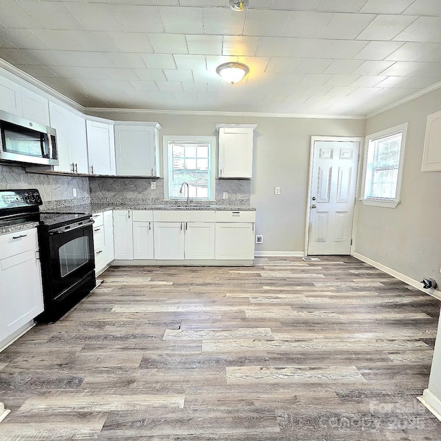 kitchen with tasteful backsplash, stainless steel microwave, ornamental molding, white cabinetry, and black electric range oven