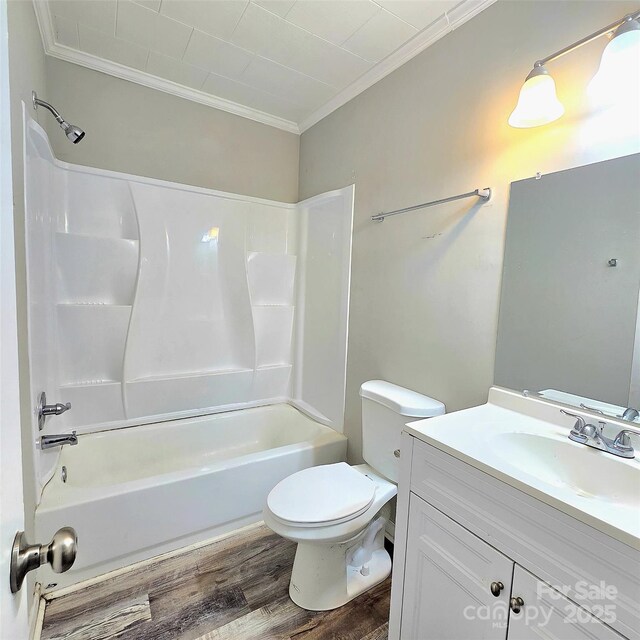 full bath featuring wood finished floors, toilet, shower / bath combination, vanity, and crown molding