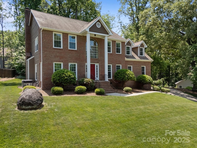 9000 Stourbridge Dr, Huntersville, NC 28078 - neoclassical home with a shingled roof, brick siding, a front yard, central AC unit, and a chimney