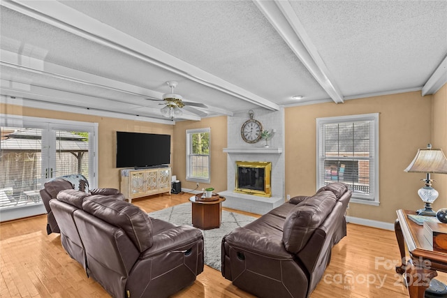 6035 Idlebrook Dr, Charlotte, NC 28212 - living area with beam ceiling, a textured ceiling, a brick fireplace, light wood-type flooring, and a ceiling fan