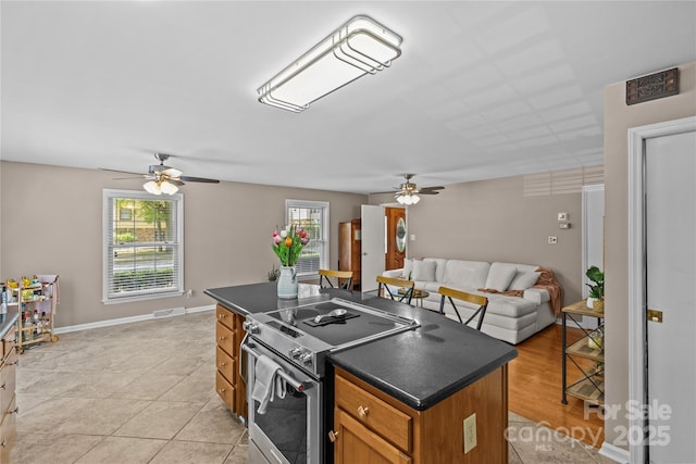 6035 Idlebrook Dr, Charlotte, NC 28212 - kitchen with electric stove, ceiling fan, open floor plan, dark countertops, and a center island