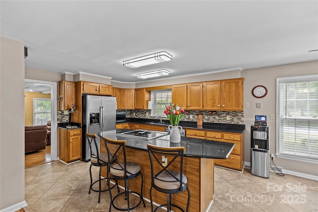 6035 Idlebrook Dr, Charlotte, NC 28212 - kitchen featuring stainless steel fridge with ice dispenser, backsplash, dark countertops, a breakfast bar, and stovetop