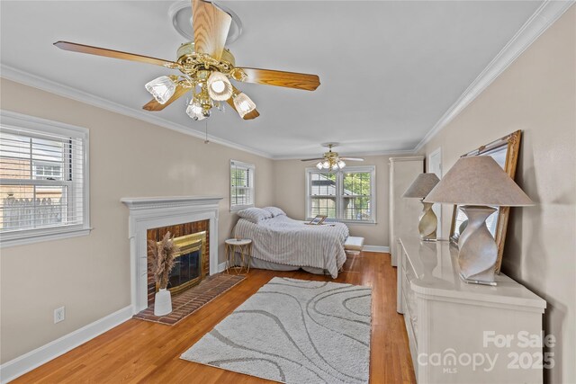 6035 Idlebrook Dr, Charlotte, NC 28212 - bedroom featuring light wood-style floors, crown molding, ceiling fan, and a brick fireplace