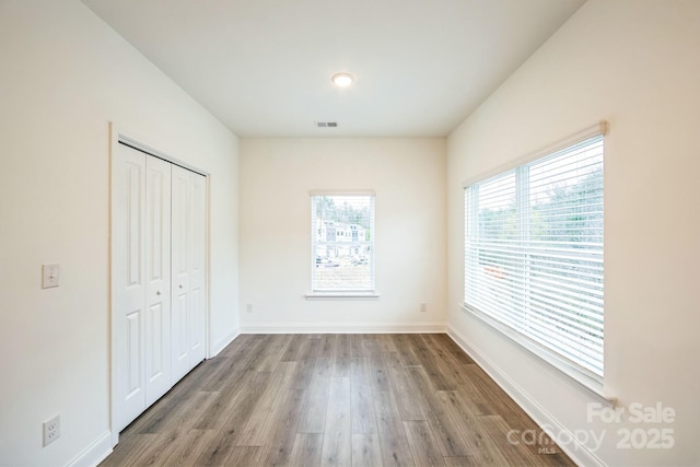 81 Walnut Springs Dr Unit 22-D, Asheville, NC 28804 - unfurnished bedroom with baseboards, wood finished floors, a closet, and visible vents