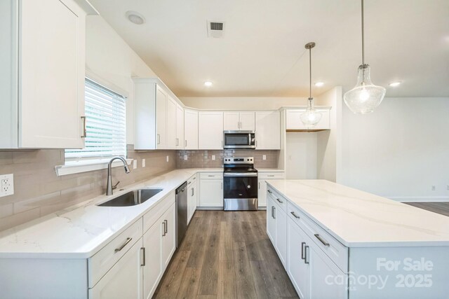 81 Walnut Springs Dr Unit 22-D, Asheville, NC 28804 - kitchen featuring visible vents, a center island, a sink, stainless steel appliances, and decorative backsplash