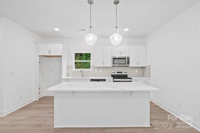 184 Cherry Springs Ln Unit 1-B, Asheville, NC 28804 - kitchen featuring visible vents, tasteful backsplash, a sink, stainless steel appliances, and white cabinetry