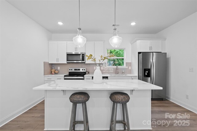 184 Cherry Springs Ln Unit 1-B, Asheville, NC 28804 - kitchen featuring appliances with stainless steel finishes, a kitchen breakfast bar, a center island, white cabinets, and recessed lighting