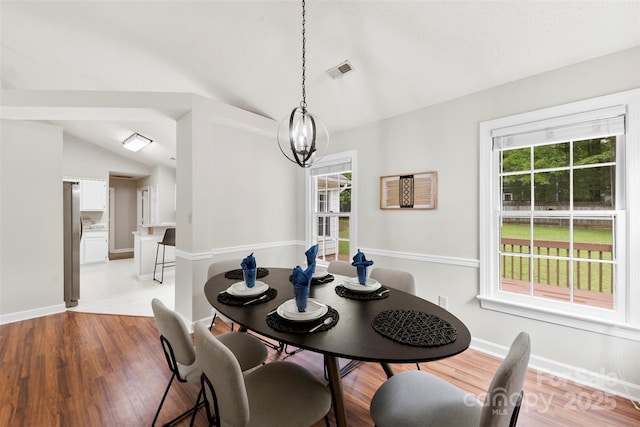 13324 Kintyre Ct, Matthews, NC 28105 - dining area featuring lofted ceiling, plenty of natural light, baseboards, a chandelier, and light wood-style floors