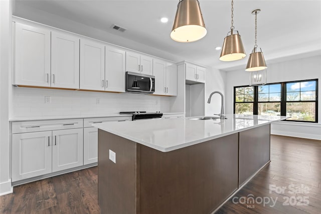 714 Falling Oak Aly Unit 18, Huntersville, NC 28078 - kitchen with stainless steel microwave, a sink, range with electric stovetop, backsplash, and dark wood-style floors