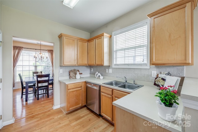 kitchen featuring a sink, stainless steel dishwasher, light wood finished floors, and light brown cabinetry