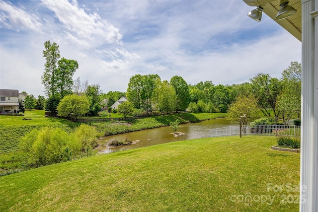 view of yard featuring a water view and fence