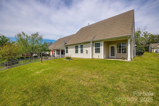 rear view of house with a patio area, fence, a lawn, and roof with shingles
