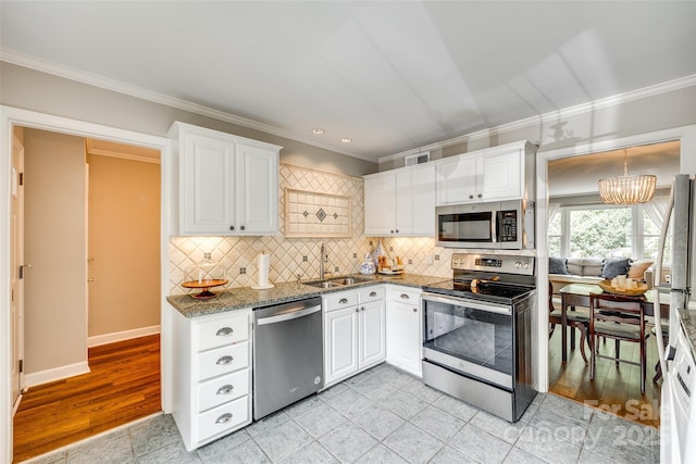4607 Hedgemore Dr Unit H, Charlotte, NC 28209 - kitchen featuring white cabinets, a sink, crown molding, tasteful backsplash, and appliances with stainless steel finishes