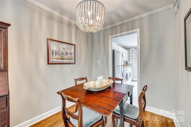 4607 Hedgemore Dr Unit H, Charlotte, NC 28209 - dining room featuring ornamental molding, baseboards, a notable chandelier, and wood finished floors