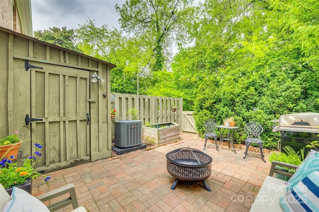 4607 Hedgemore Dr Unit H, Charlotte, NC 28209 - view of patio with fence, central air condition unit, grilling area, an outdoor structure, and an outdoor fire pit