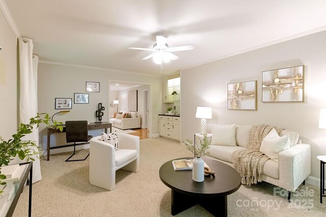 living area with light carpet, a ceiling fan, baseboards, and ornamental molding