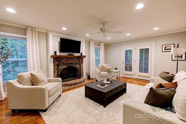 living area featuring crown molding, wood finished floors, and recessed lighting