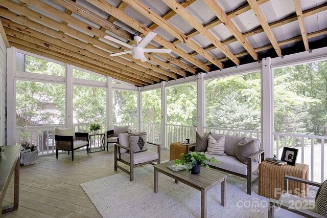 sunroom / solarium featuring a ceiling fan and an outdoor living space