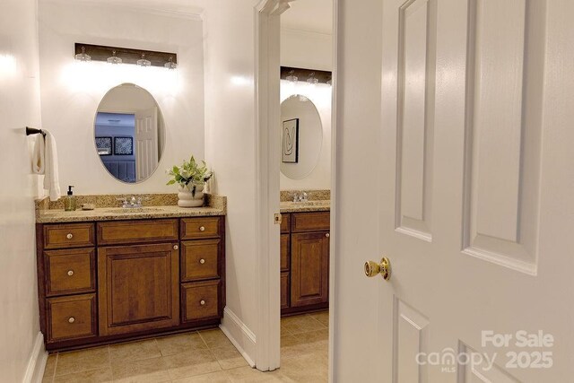 bathroom with baseboards, vanity, and tile patterned flooring