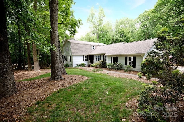 view of front of home with a shingled roof and a front lawn