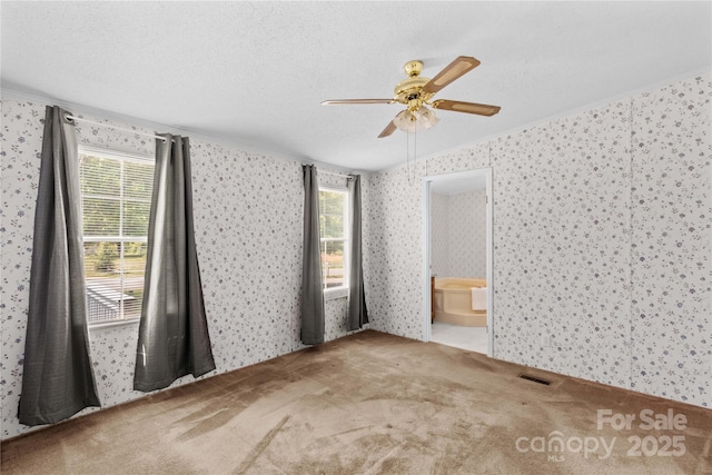unfurnished room featuring wallpapered walls and visible vents