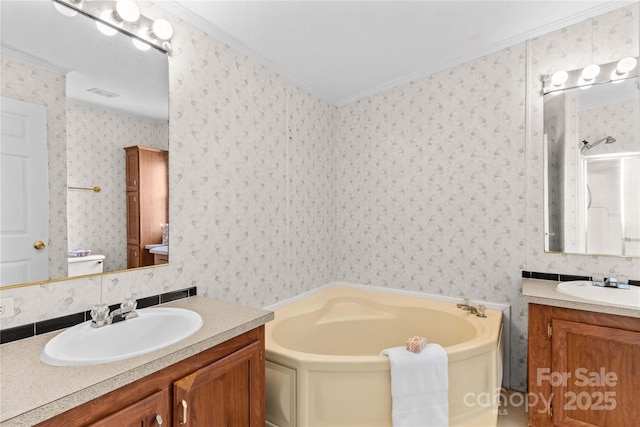 bathroom featuring two vanities, a garden tub, a sink, and ornamental molding