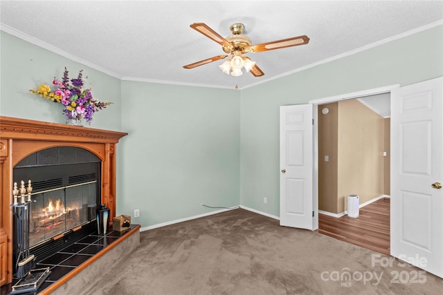 unfurnished living room featuring carpet flooring, a ceiling fan, baseboards, and ornamental molding