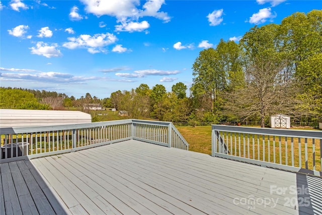wooden deck featuring a yard, an outbuilding, and a shed