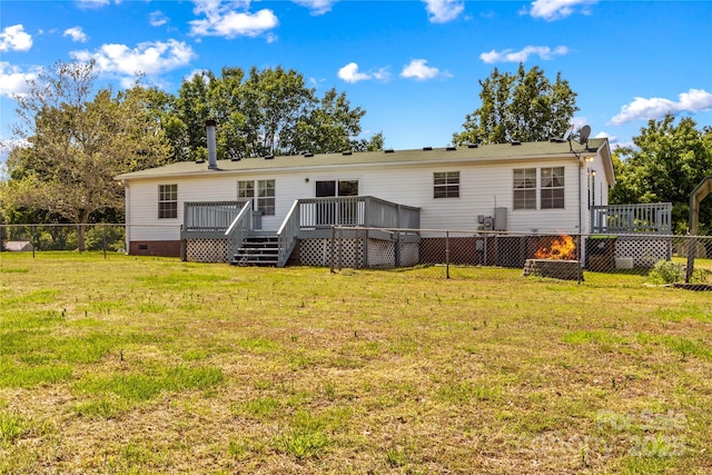 back of property featuring crawl space, a fenced backyard, a wooden deck, and a yard