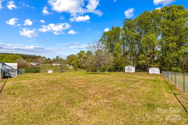 view of yard with a fenced backyard, an outdoor structure, and a shed