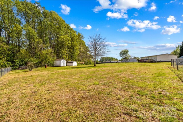view of yard featuring fence, an outbuilding, and a storage shed