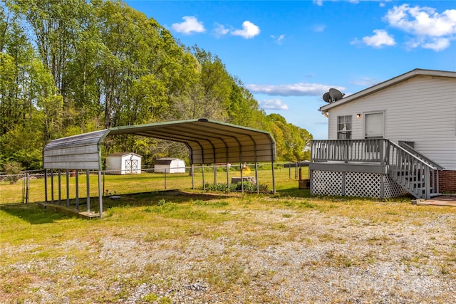 view of vehicle parking with fence, a gate, a detached carport, and a shed