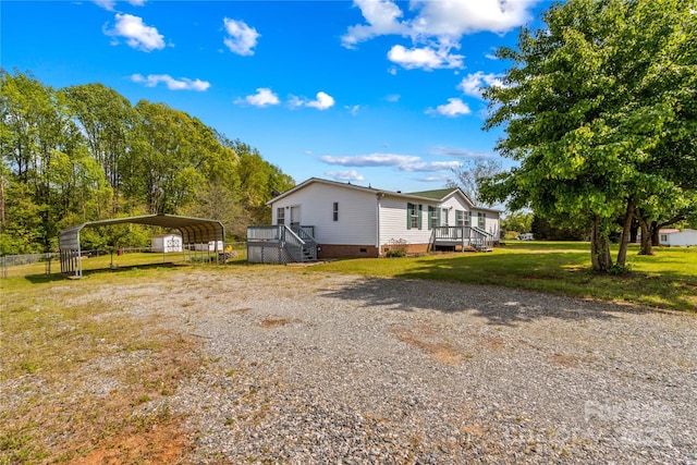 view of side of home featuring crawl space, a carport, a yard, and driveway