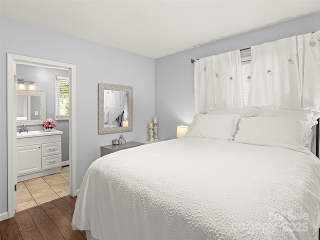 bedroom featuring a sink, dark wood-style flooring, and ensuite bath