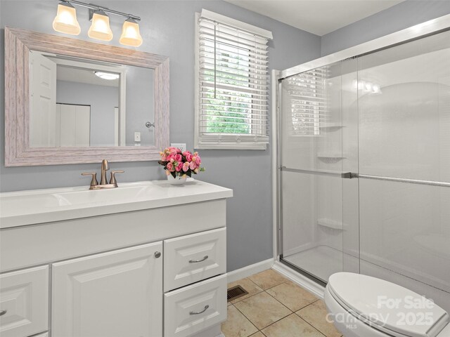 full bathroom featuring vanity, tile patterned floors, toilet, a stall shower, and baseboards