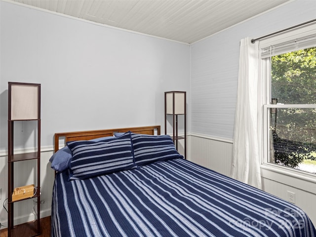 bedroom with wood finished floors and crown molding