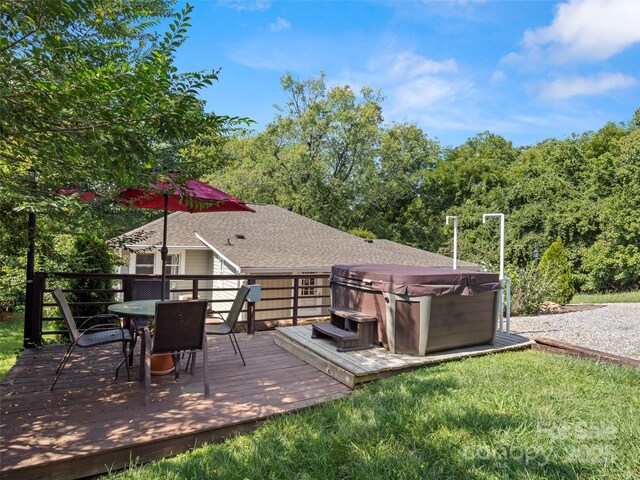exterior space with a deck, a lawn, outdoor dining area, and a hot tub