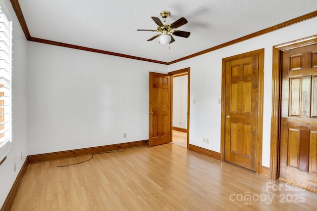 unfurnished bedroom featuring crown molding, light wood finished floors, baseboards, and multiple windows