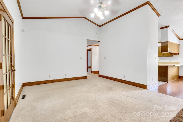unfurnished living room featuring baseboards, ornamental molding, ceiling fan, carpet floors, and high vaulted ceiling