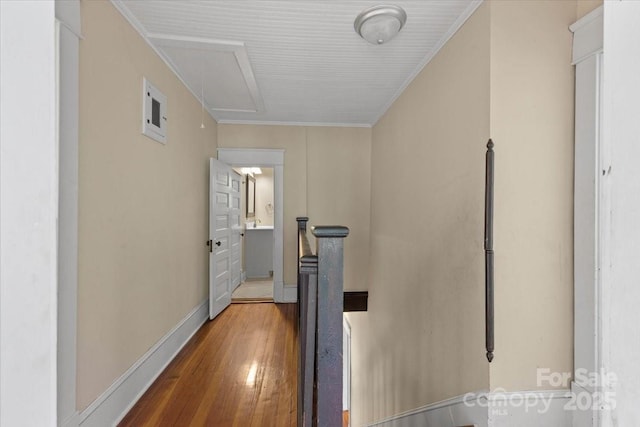 hall with attic access, baseboards, an upstairs landing, wood finished floors, and ornamental molding