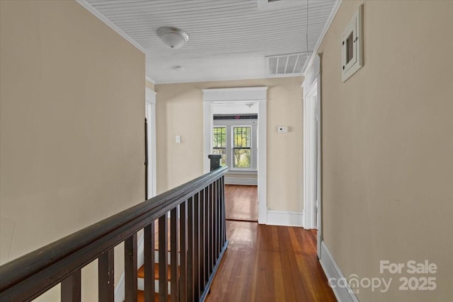 corridor with hardwood / wood-style flooring, baseboards, an upstairs landing, and visible vents