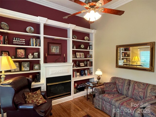 121 General Pemberton St, Stanley, NC 28164 - living room featuring built in features, a fireplace, ornamental molding, a ceiling fan, and wood finished floors