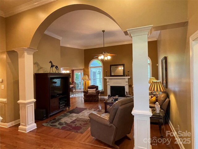121 General Pemberton St, Stanley, NC 28164 - living area featuring a fireplace, a ceiling fan, decorative columns, arched walkways, and wood finished floors