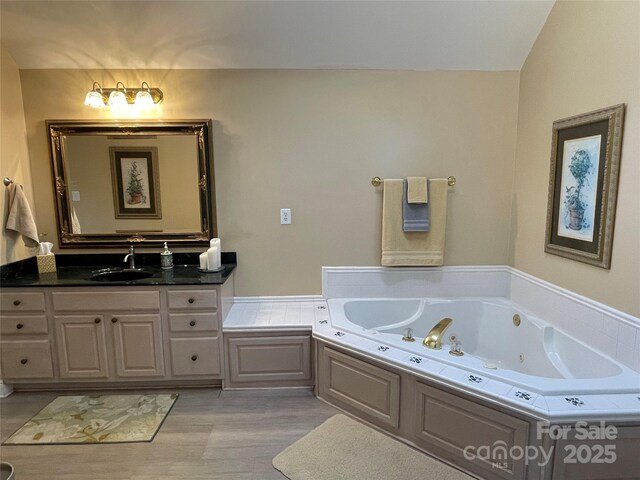 121 General Pemberton St, Stanley, NC 28164 - bathroom with vanity, a tub with jets, and wood finished floors