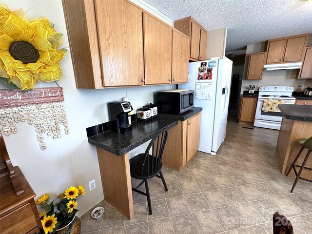 2084 Bristol Creek Ave, Morganton, NC 28655 - kitchen featuring dark countertops, a breakfast bar area, under cabinet range hood, and white appliances